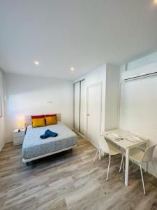1 dormitorio con 1 cama y 1 mesa con sillas en MINI ESTUDIOS SANSE, en San Sebastián de los Reyes