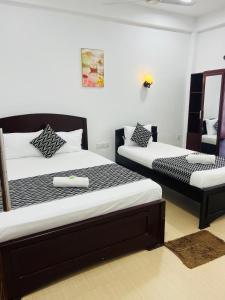 a bedroom with two beds and a mirror at Blue Diamond Resort in Trincomalee