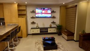 uma sala de estar com televisão e um bar em Departamento 2B en Condominio La Victoria em Cuenca