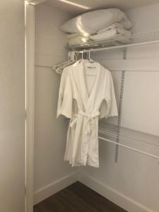 a white robe hanging on a rack in a closet at Hot Tub Hideaway in Shawnigan Lake