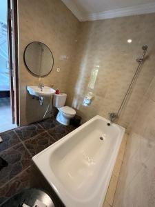 Munduk Sari Resort في موندوك: حمام مع حوض ومرحاض ومغسلة