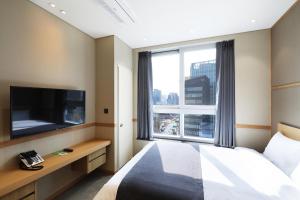 a hotel room with a bed and a large window at The Stay Classic Hotel Myeongdong in Seoul