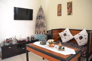 a living room with a coffee table and a tv at Roemah Canting Homestay in Yogyakarta