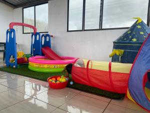 una sala de juegos para niños con un perro en un tobogán inflable en Hostal Vista al Mar, en Puerto Baquerizo Moreno