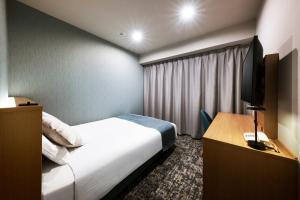 a hotel room with a bed and a television at Hotel Villa Fontaine Tokyo-Kayabacho in Tokyo