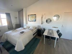 sypialnia z białym łóżkiem i stołem w obiekcie Guesthouse Vatnsholt w mieście Vatnsholt