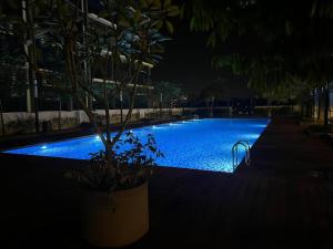 a swimming pool at night with a tree in the foreground at Pacific Tower PJ Section 13 WifiParkingOppJayaOne Mall in Petaling Jaya