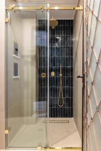 a shower with a glass door in a bathroom at Αρχοντικό Κίτσου - BOUTIQUE HOTEL in Kastoria