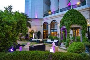 un hotel con jardín frente a un edificio en Hotel The Royal Plaza, en Nueva Delhi