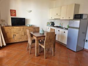 una cucina con tavolo, sedie e frigorifero di Beach front ocean view Porto Antigo2 Santa Maria a Santa Maria