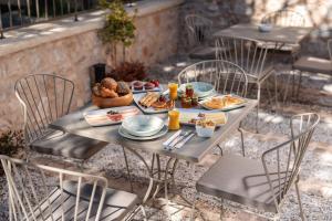 a table with plates of food on it at Αρχοντικό Κίτσου - BOUTIQUE HOTEL in Kastoria
