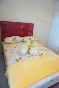 a bed with yellow sheets and pillows in a bedroom at Kembang Homestay Yogyakarta in Seturan