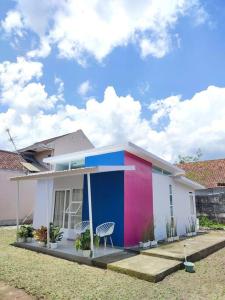 ein farbenfrohes Haus mit einem Stuhl davor in der Unterkunft Kembang Homestay Yogyakarta in Seturan