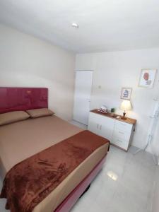 a bedroom with a large bed and a night stand at Kembang Homestay Yogyakarta in Seturan