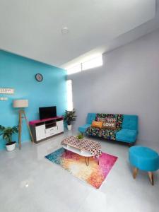 a living room with a blue couch and a tv at Kembang Homestay Yogyakarta in Seturan