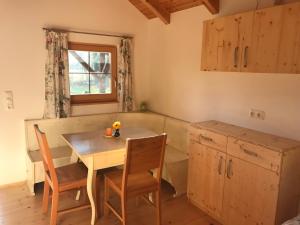 eine Küche mit einem Tisch und Stühlen sowie einem Fenster in der Unterkunft Tiny Home am Bach in Pettenbach