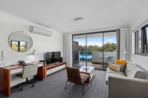 ein Wohnzimmer mit einem Sofa und einem Schreibtisch in der Unterkunft Quest Kelvin Grove in Brisbane
