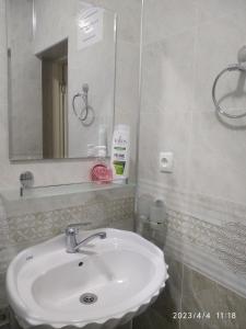 a bathroom with a white sink and a mirror at Nur-Niso Guest House in Bukhara
