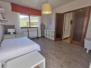 a bedroom with a white bed and a large window at Monteferro, Nigrán, chalet con finca in Nigrán