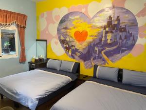 two beds in a room with a heart mural at Green Island Xinmanyuan綠島馨滿園 in Green Island