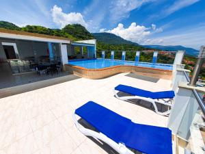 uma casa com uma piscina e duas espreguiçadeiras azuis em Hermoso Apto - C.C San Gil Plaza em San Gil