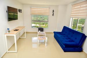 a living room with a blue couch and a desk at Hermoso Apto - C.C San Gil Plaza in San Gil