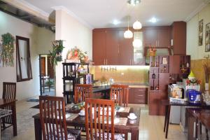 a kitchen with a table and chairs and a refrigerator at Roemah Canting Homestay in Yogyakarta