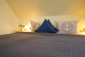 a bedroom with a bed with blue and white pillows at Ferienwohnung Strandaster in Spieka-Neufeld