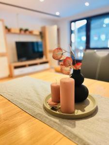 a table with a candle and a vase on a table at Modernes Apartment Seefeld and Chill RELAX im Zentrum mit Netflix for free in Seefeld in Tirol