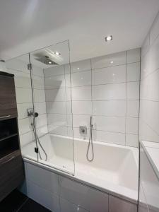uma banheira com um chuveiro em vidro na casa de banho em Modernes Apartment Seefeld and Chill RELAX im Zentrum mit Netflix for free em Seefeld no Tirol