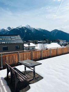stół i ławka na balkonie ze śniegiem w obiekcie Modernes Apartment Seefeld and Chill RELAX im Zentrum mit Netflix for free w mieście Seefeld in Tirol
