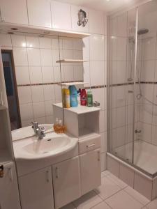 uma casa de banho branca com um lavatório e um chuveiro em Private Studio Apartment with Balcony in Dortmund-Brackel em Dortmund