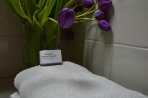 un vase rempli de tulipes violets dans une salle de bains dans l'établissement Gästezimmer Klinger-Tongisch, à Apetlon