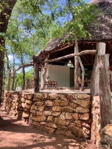 a stone house with a stone wall at Lemara Eco Camp in Kisaki