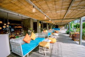 a row of chairs and tables on a patio at IKOSHAROLD Suites Seminyak in Seminyak