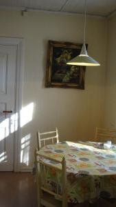 uma sala de jantar com uma mesa e uma imagem na parede em Hiirevända Holiday House em Võsu
