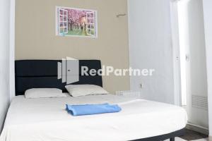 un letto con un cuscino blu seduto sopra di Cosmo Harmoni RedPartner a Giacarta