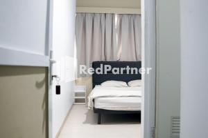Postel nebo postele na pokoji v ubytování Cosmo Harmoni RedPartner