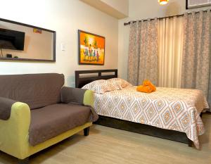 Un dormitorio con una cama y un sofá con un animal de peluche. en JCM- Studio Deluxe Room, en Manila