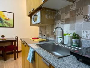 a kitchen with a sink and a microwave at JCM- Studio Deluxe Room in Manila
