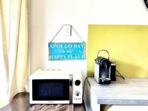 - un four micro-ondes installé sur une table dans l'établissement Beachfront Holiday Home, à Apollo Bay
