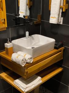 a bathroom sink on a wooden shelf with towels at Dumani Nagar Hotel & Resort in Hunza Valley