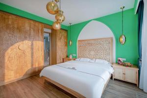 a bedroom with a white bed and green walls at Morocco Green House Forest in Huidong