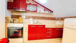 a kitchen with red cabinets and a red oven at The Sunshine apartment in Prilep