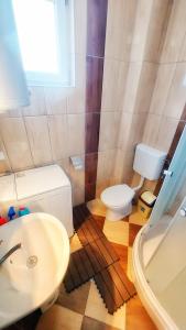 een badkamer met een witte wastafel en een toilet bij The Sunshine apartment in Prilep
