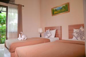 Postel nebo postele na pokoji v ubytování Roemah Canting Homestay