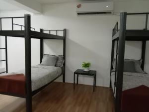 1 Schlafzimmer mit 2 Etagenbetten und einem Tisch in der Unterkunft Doodle Lodge Bangkok in Bangkok