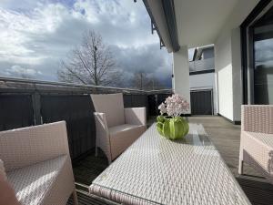 een tafel en stoelen op een balkon met een vaas erop bij Luxuriöse Wohnung Zentral mit großem Balkon in Losheim