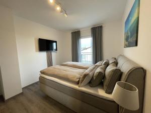 ein Schlafzimmer mit einem Bett mit einem Sofa und einem Fenster in der Unterkunft Luxuriöse Wohnung Zentral mit großem Balkon in Losheim