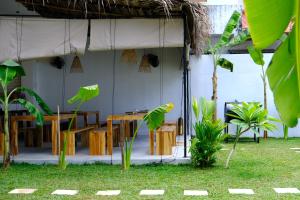 a restaurant with tables and chairs in the grass at OASIA - Boutique Surf House (ADULTS ONLY) in Weligama